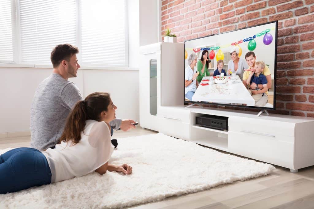 Couple Watching Party Celebration Video On Television