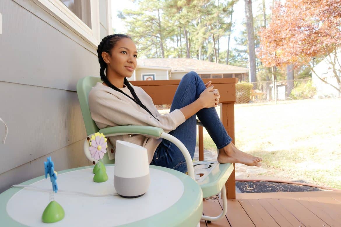 Girl On A Chair Next To Google Home