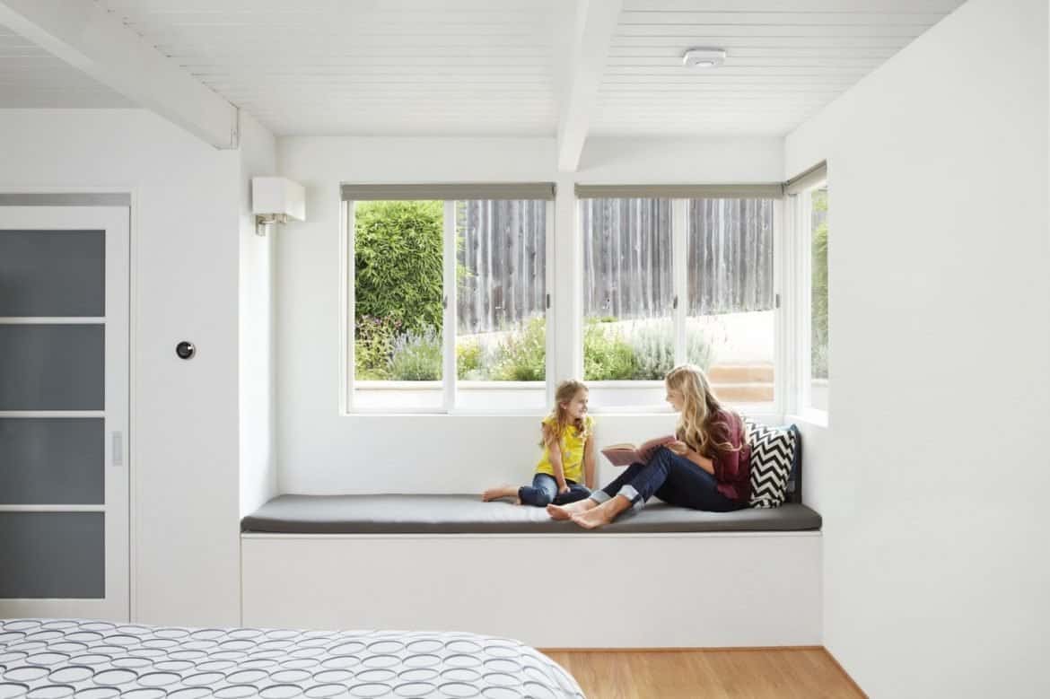 Family sitting under a fitted Best Smart Wi-Fi Smoke Detectors