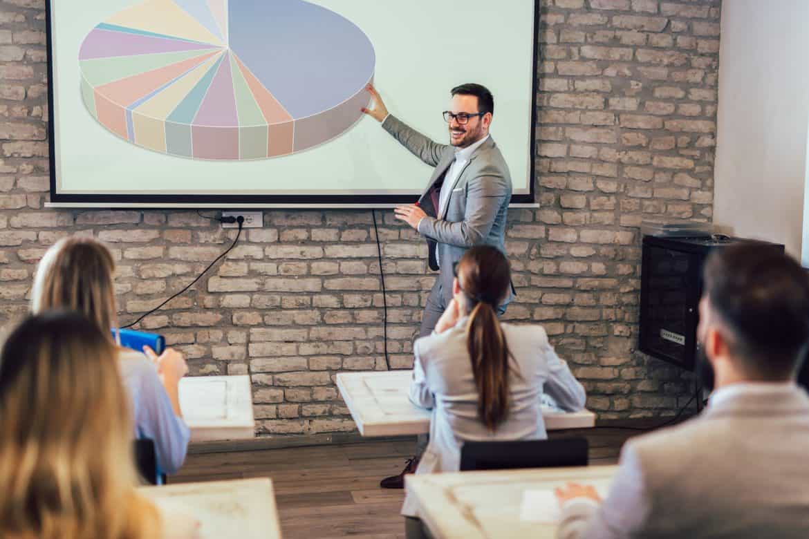 Confident speaker giving public presentation using projector in