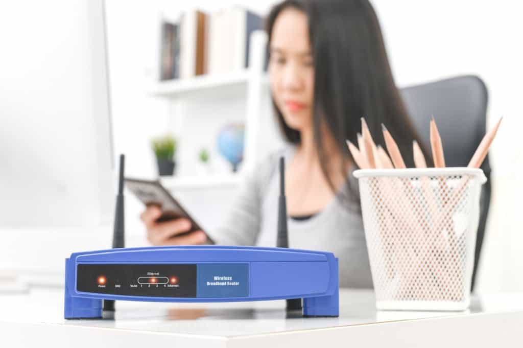 Girl sitting behind a Basic Wireless router.jpg