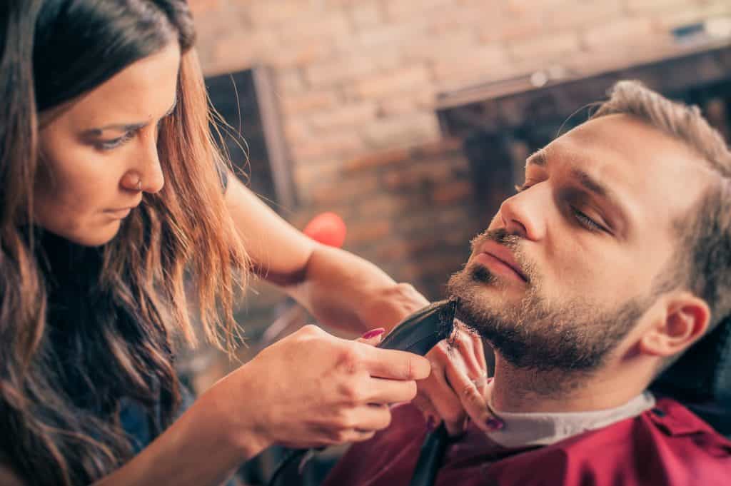 Barber shaving a client with trimmer