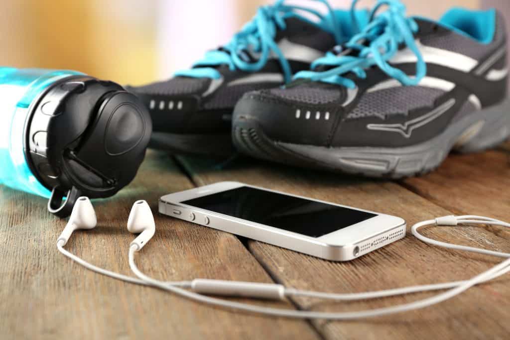Sneakers and earphones on wooden table, closeup