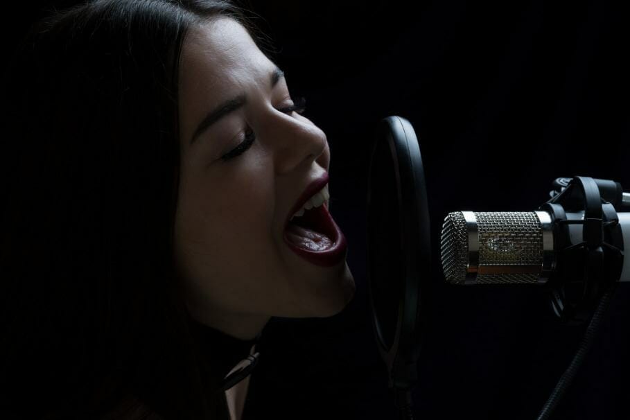 woman singing into a BLUE microphone yeti